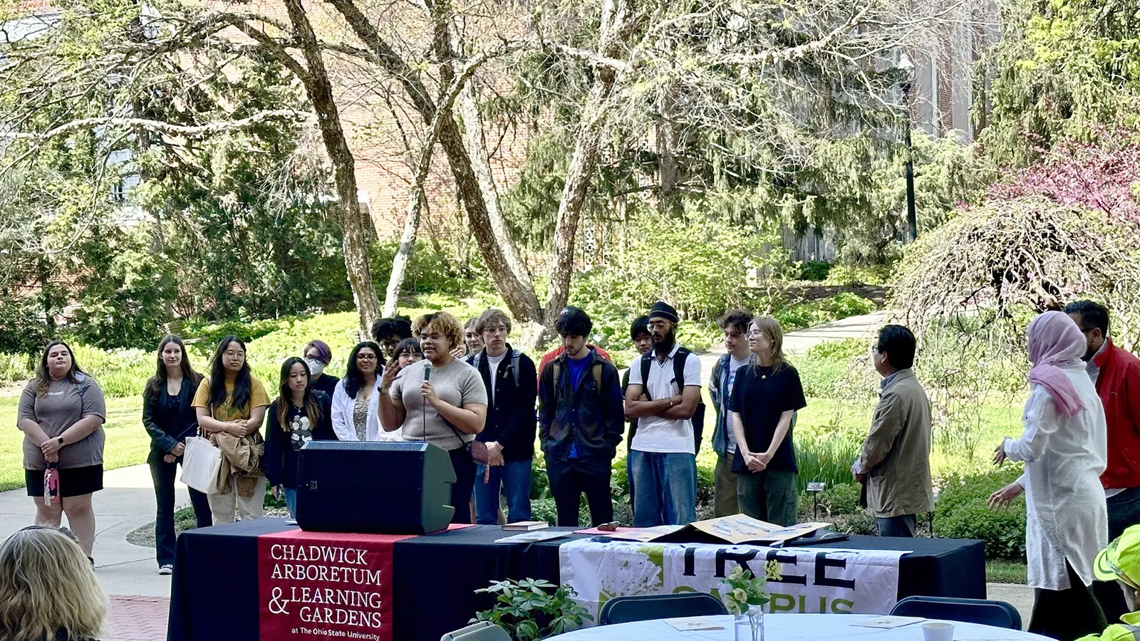 Students presenting at a podium outside. 