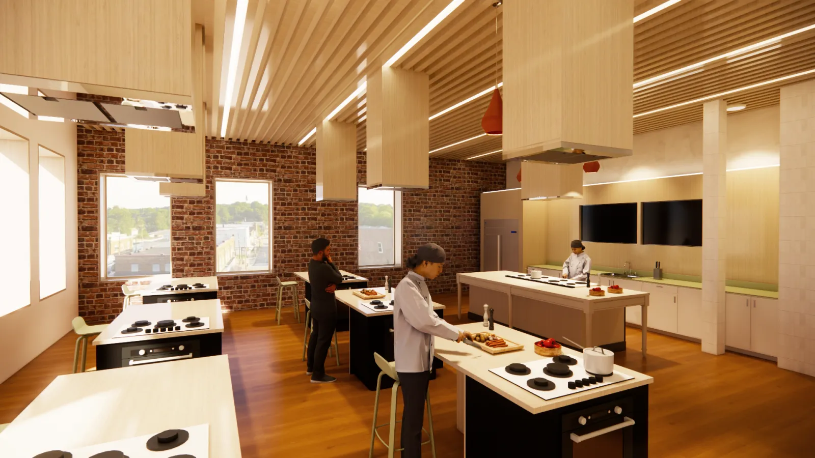 This perspective is at the entrance of the Instructional Kitchen where rows of personal cooking stations are seen with the instructor station at the front and two large monitors on the back wall to allow for cooking demonstrations to be streamed.