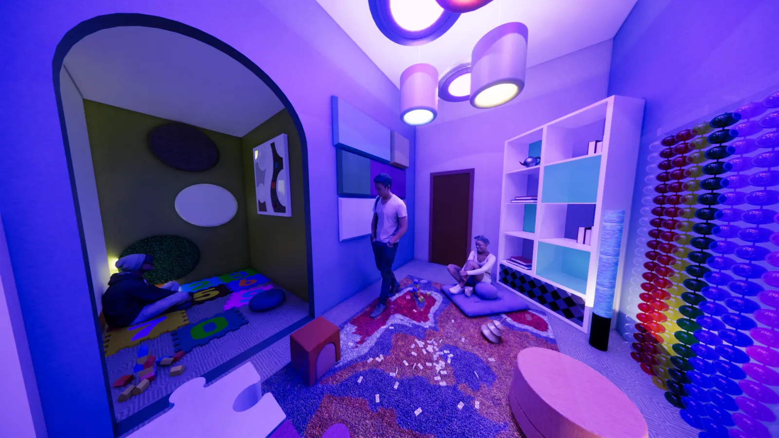 A sensory room with dim, purple-blue lighting features various interactive elements. A small enclosed sensory pod on the left has a person sitting on a cushioned floor with tactile wall panels and soft toys. The main area includes a carpet with scattered puzzle pieces, a man standing, and a person sitting on a cushion. The right side has a white bookshelf with books and decorative items, a bubble tube light, and a vibrant wall installation made of colorful, translucent discs. The ceiling has circular pen