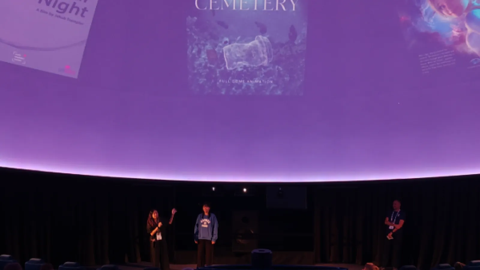 Students speak on planetarium stage.