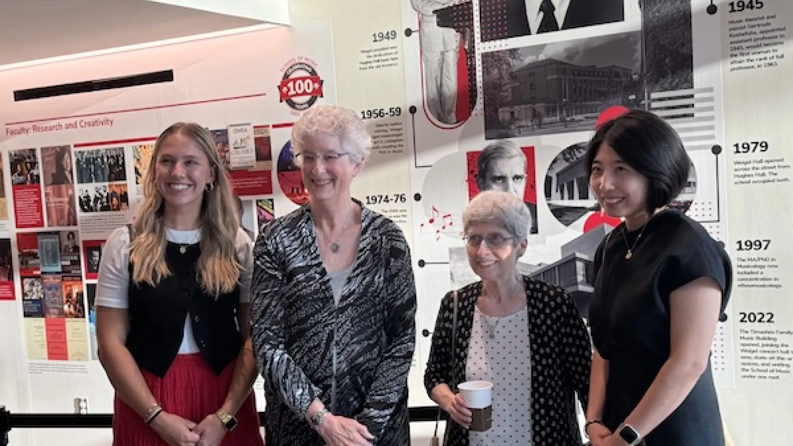 Borami Kang and Emily Holt with committee co-chairs Katherine Borst Jones and Lois Rosow, in front of legacy wall. 