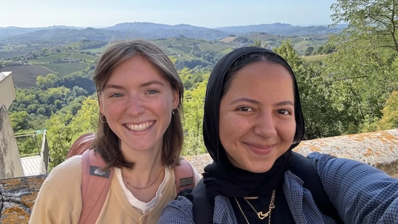 Tess on the Left and Aya on the right in front of a beautiful Italian vista.