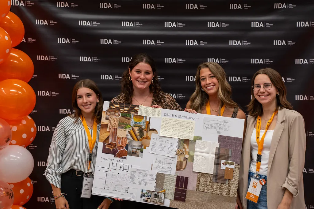 Four students presenting an interior design project board at the IIDA Student Conference.